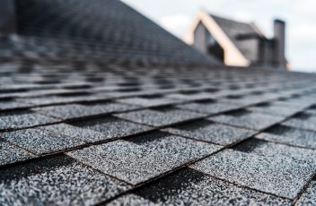 selective focus of grey shingles on rooftop of building